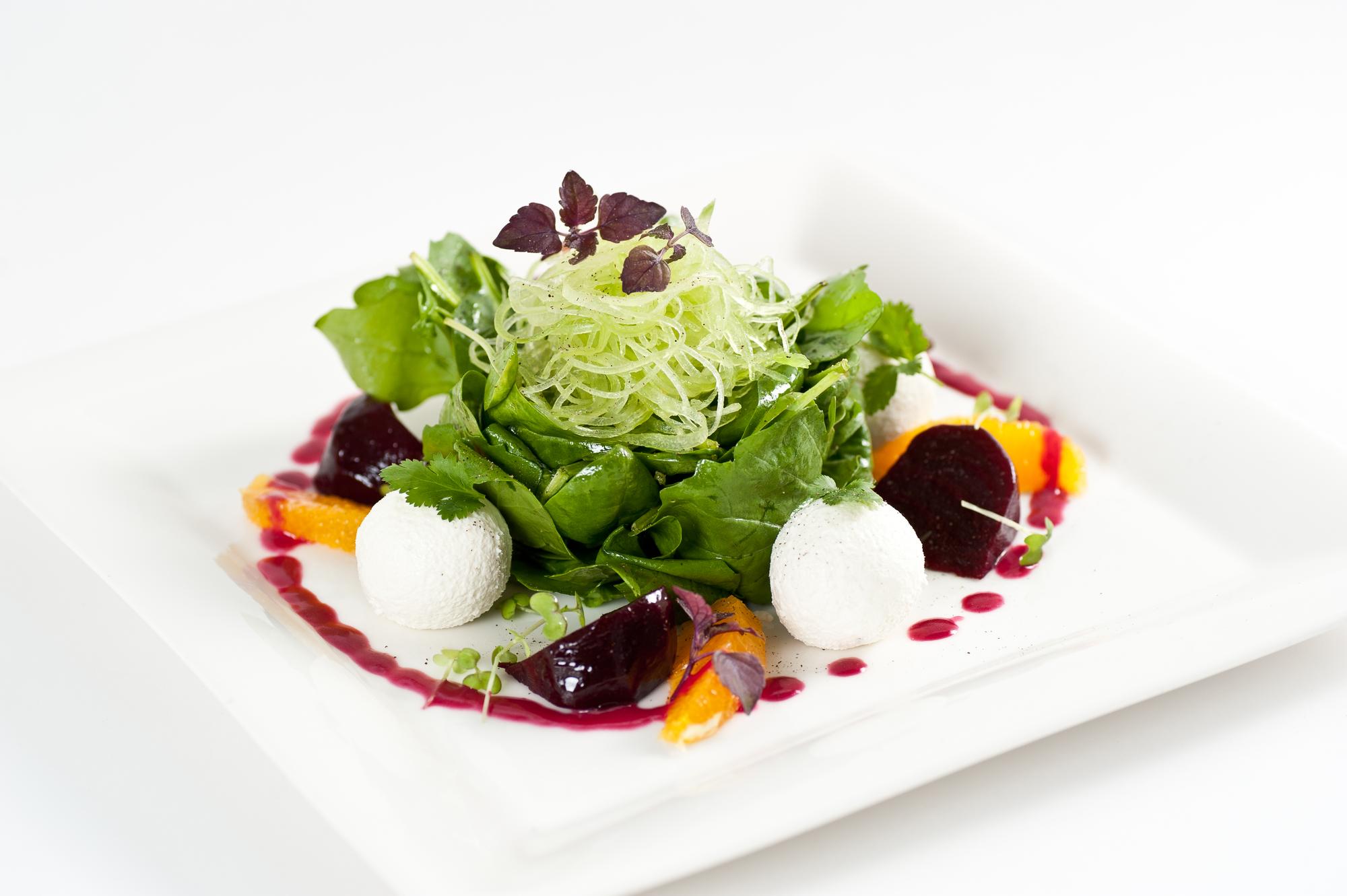 Chef plating a composed seasonal salad